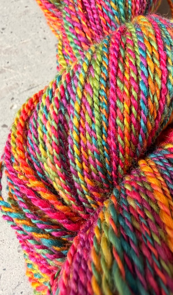 Hand-spun, rainbow-dyed twisted yarn skein